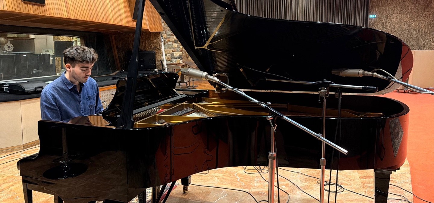 Christos Anagnostou Daly playing a grand piano in a recording studio