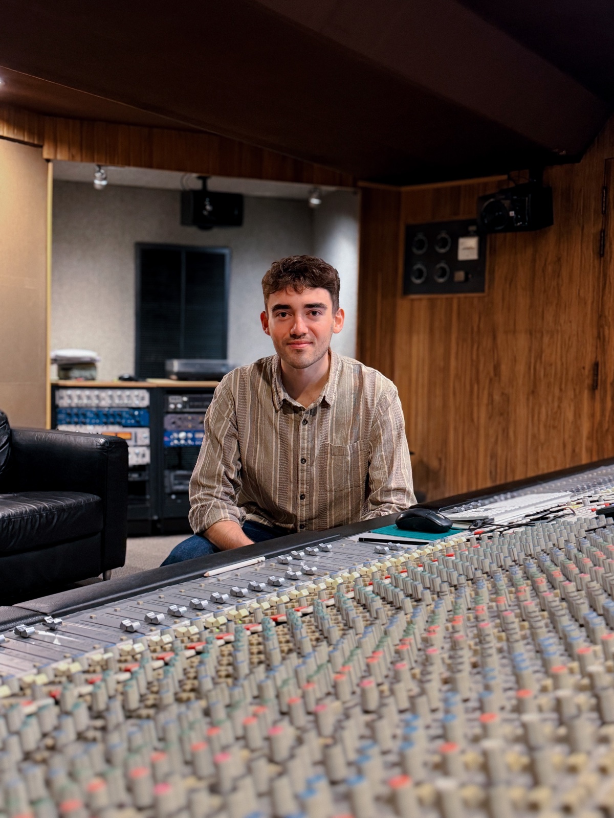 Christos Anagnostou Daly seated at a mixing console in a recording studio